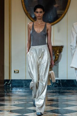 MILAN, ITALY - 25 Şubat 2023 'te Milano Moda Haftası Kadın Giyim / Kış 2023' te İtalya 'nın Milano kentinde düzenlenen Ermanno Scervino defilesinde bir model podyumda yürüyor..