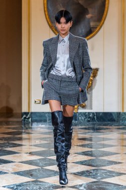 MILAN, ITALY - 25 Şubat 2023 'te Milano Moda Haftası Kadın Giyim / Kış 2023' te İtalya 'nın Milano kentinde düzenlenen Ermanno Scervino defilesinde bir model podyumda yürüyor..