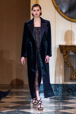 MILAN, ITALY - 25 Şubat 2023 'te Milano Moda Haftası Kadın Giyim / Kış 2023' te İtalya 'nın Milano kentinde düzenlenen Ermanno Scervino defilesinde bir model podyumda yürüyor..