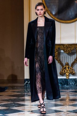 MILAN, ITALY - 25 Şubat 2023 'te Milano Moda Haftası Kadın Giyim / Kış 2023' te İtalya 'nın Milano kentinde düzenlenen Ermanno Scervino defilesinde bir model podyumda yürüyor..