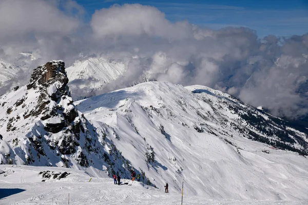 アルプスの美しいピークの息をのむような景色の周りのメリベルスキーリゾートでスキーをする人々のグループ ロイヤリティフリーのストック画像