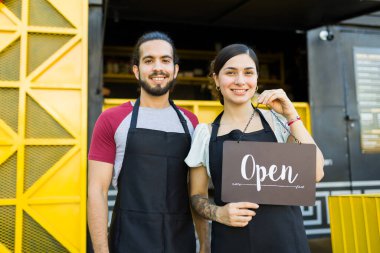 Cheerful stall vendor and cook smiling after opening the fast food truck  clipart