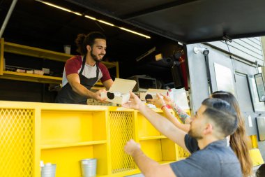 Mutluluk aşçısı yemek kamyonunda birkaç müşteriye fast food servisi yapıyor.