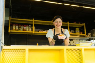 Mutlu kadın şef yemek kamyonunda müşterilere fast food servisi yapmaya hazır.