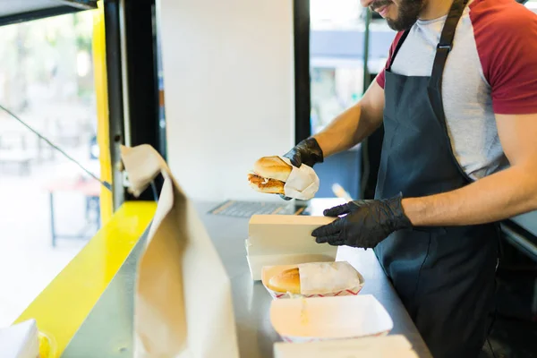 フードトラックでおいしいサンドイッチを準備手袋でヒスパニック料理の側面図 — ストック写真