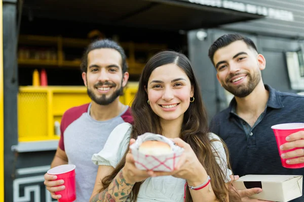 매력적 친구들은 카메라를 보면서 패스트푸드 트럭에서 맛있는 샌드위치를 즐긴다 — 스톡 사진