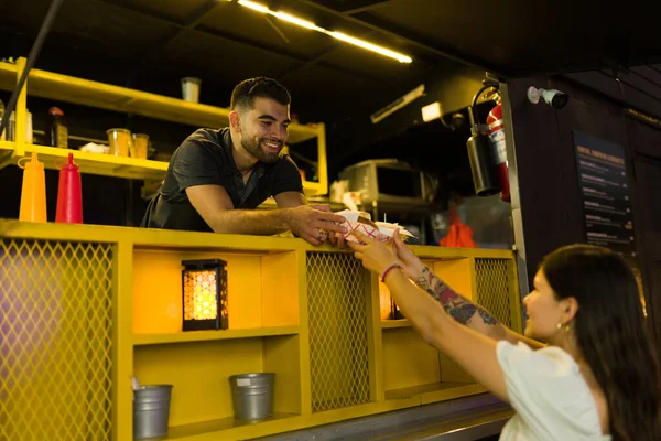 幸せなフードトラックの労働者幸せな女性においしいディナーを提供していますストリートフードを注文する — ストック写真