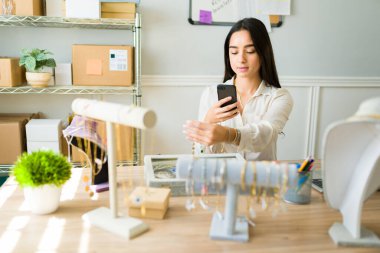 Güzel genç bir kadın internete takı yüklüyor ve internette satıyor.