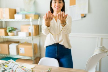 Çevrimiçi dükkanının mücevherlerini gösteren bir kadın girişimcinin ön planına odaklan