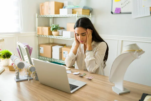 オンラインジュエリー店で働く中でストレスを感じている頭痛の種の女性起業家 — ストック写真