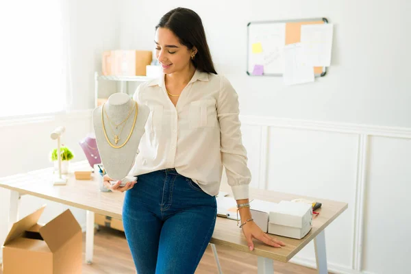幸せなオンライン販売人は彼女のオンライン店の宝石類を示しながら家から働く笑みを浮かべて — ストック写真