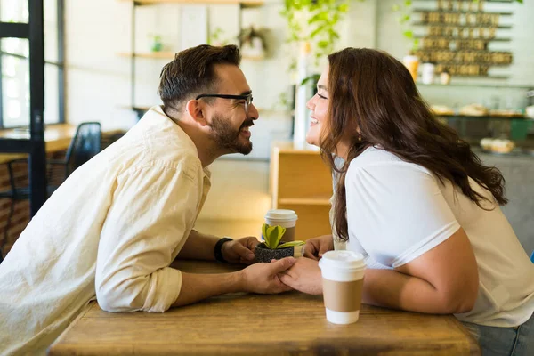 陽気Caucasian男とラテン脂肪女性笑顔と約キス中に日付でザコーヒーショップ — ストック写真