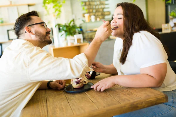 ロマンチックな男給餌デザートへ彼の幸せな大ガールフレンドに彼らの日にコーヒーショップで — ストック写真