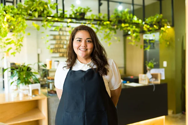 コーヒーショップやレストランでバリスタやウェイトレスとして働く美しいヒスパニック系の太った女性 — ストック写真