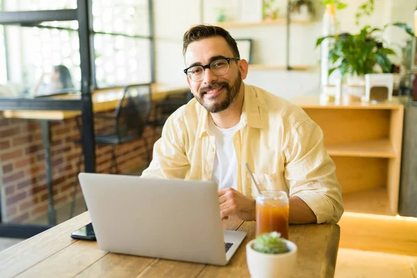 Attraktiver Glücklicher Mann Lächelt Café Während Mit Seinem Laptop Arbeitet — Stockfoto