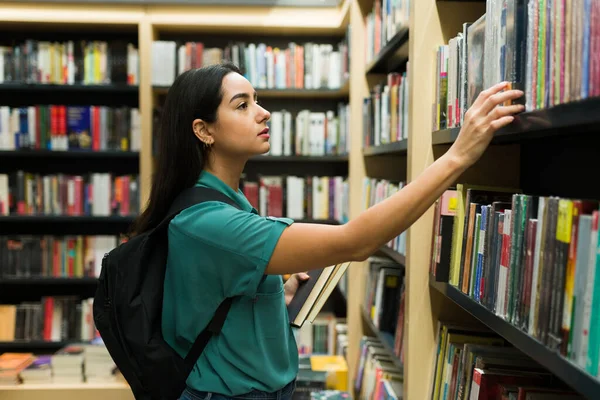 Vista Lateral Uma Estudante Universitária Olhando Para Comprar Livro Olhando — Fotografia de Stock