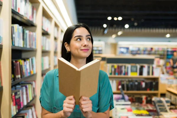 Sorrindo Jovem Mulher Pensando Usando Sua Imaginação Ler Livro Interessante — Fotografia de Stock