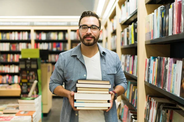 Homem Atraente Feliz Carregando Monte Livros Enquanto Faz Compras Livraria — Fotografia de Stock