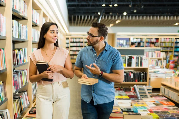 白种人年轻人在书店买书的时候和一个漂亮的女人聊天 — 图库照片