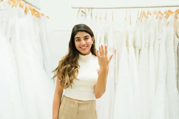 ウェディングドレスを買いながら婚約指輪を見せる婚約者の女性と未来の花嫁 — ストック写真