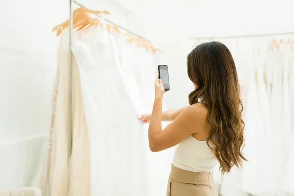 美しいウェディングドレスで彼女の携帯電話で写真を撮る将来の花嫁のリアビュー — ストック写真