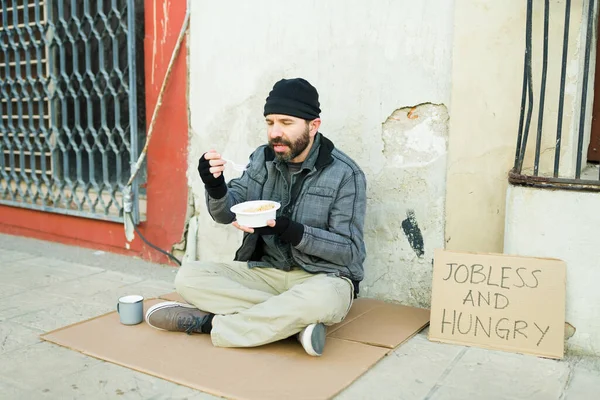 ホームレスの病人がスープを食べて路上生活をしながら独り言を言う — ストック写真