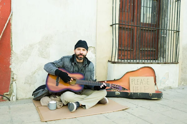 男は貧困の中で歌を歌うためにギターを演奏し 路上でお金を求め生活乞食 — ストック写真