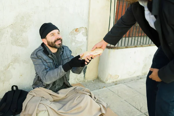 路上で優しい青年から食べ物を受け取りながら笑顔幸せなホームレス乞食男 — ストック写真