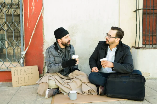 親切な白人男性悲しいホームレスの乞食の男と路上で話してコーヒーを飲む — ストック写真