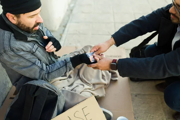 一个善良的男人给了一个住在街上留着胡子的可怜的饥饿的无家可归的男人一大笔钱 — 图库照片