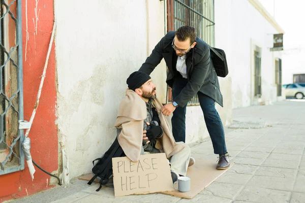 Młody Człowiek Robi Dobroczynność Szerzy Życzliwość Dając Koc Zimnemu Bezdomnemu — Zdjęcie stockowe