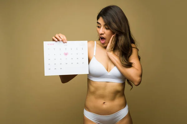 Удивлённая Спортсменка Белых Трусах Выглядит Шокированной Показывая Календарь Месячных — стоковое фото