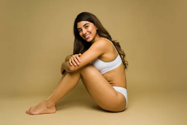 Zijaanzicht Van Een Gelukkig Latijn Vrouw Knuffelen Haar Knieën Terwijl — Stockfoto