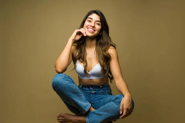 Onnellinen Kaunis Latino Nainen Katsekontaktin Etsiessään Rento Istuu Rintaliivit Farkut — kuvapankkivalokuva