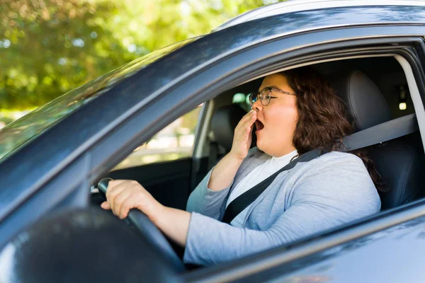 睡眠脂肪ラテン女性Yawningと見て疲れて後に運転と通勤で彼女の車 — ストック写真