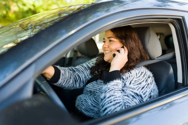 友人とスマホを呼びながら運転しながら笑顔で朗らかな太りすぎの女性 — ストック写真