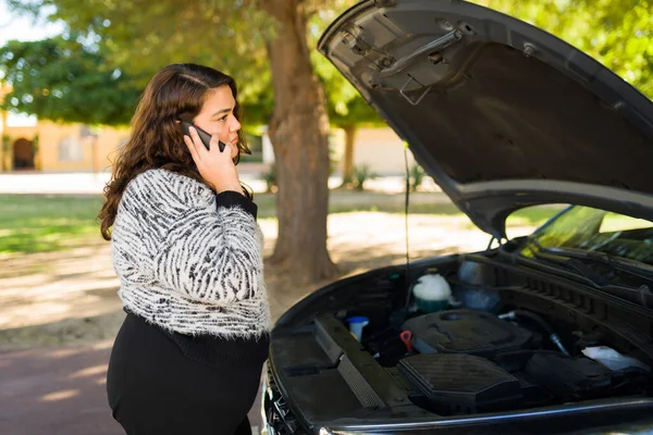 壊れた車のためにスマートフォンで助けを求める悲しい太りすぎの女性 — ストック写真