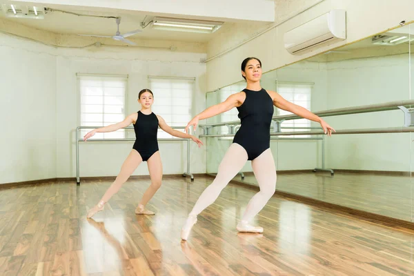 在健身学校练习芭蕾舞的年轻女子和小芭蕾舞演员 — 图库照片