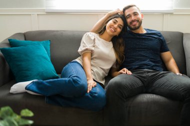 Çekici, rahat bir çift birbirine sarılıyor ve rahatlamış ve mutlu görünüyor.