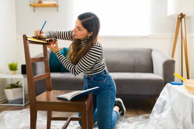 Mobilya çevirme projesine başlayıp dekorasyonunu değiştirmeye hazırlanan genç bir kadın.