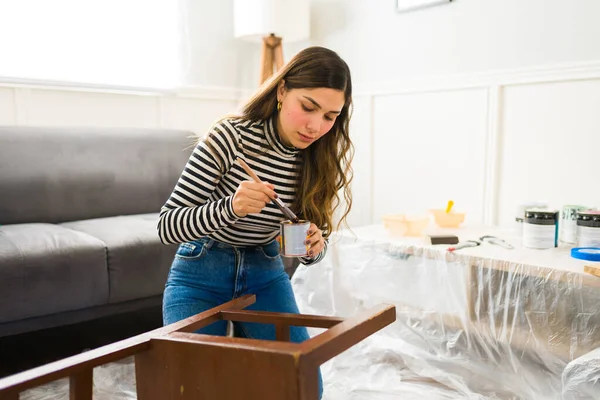 自宅で椅子を描きながら家の改善や改装を行う魅力的な女性 — ストック写真