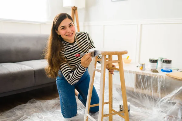 家具を塗装しながら幸せそうな笑顔で陽気な女性と死ぬ修復プロジェクトを行う — ストック写真