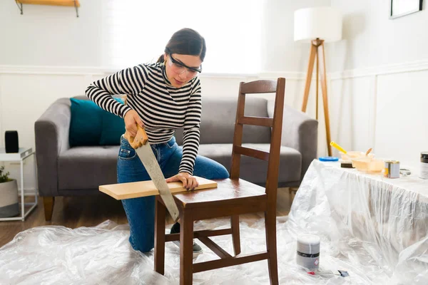 木を切りながら家具をめくる若い女性 — ストック写真