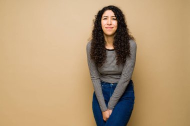 20 'li yaşlarındaki stresli İspanyol kadının çişi gelmiş ve çişini tutamama sorunu var.