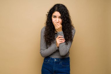 Mide bulantısı çeken ve kusmak isteyen genç Latin bir kadın.