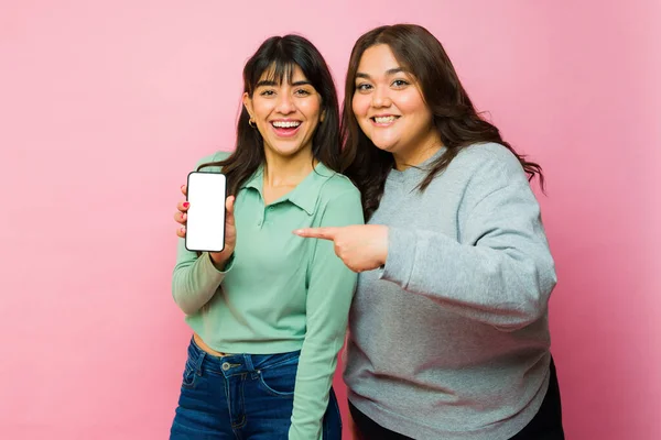 Cheerful Latin Women Friends Pointing Smartphone Texting Using Social Media — Stockfoto