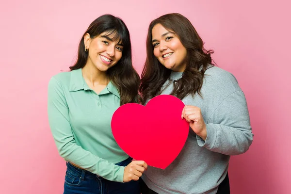 Portrait Attractive Mexican Friends Holding Big Red Heart Showing Friendship — Stockfoto