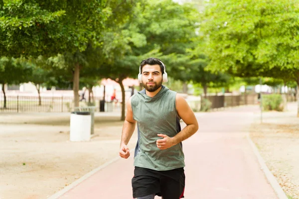 Fit Young Man Running Park Wearing Headphones Listening Music While — Stock Photo, Image