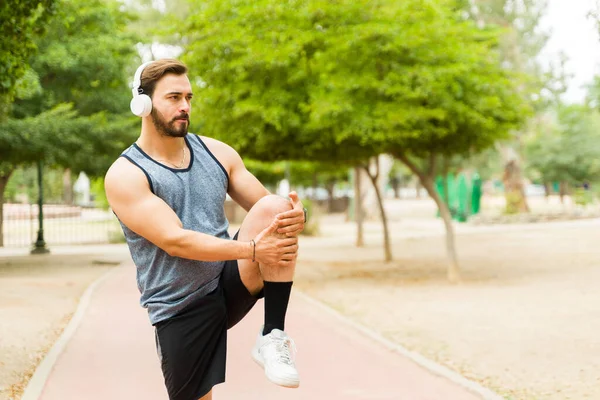 Strong Caucasian Man Headphones Stretching His Legs Warming Exercising Outdoors — Stock Photo, Image