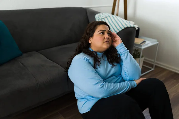 Hispánská Smutná Žena Vypadá Unaveně Sklíčeně Zatímco Sedí Obývacím Pokoji — Stock fotografie
